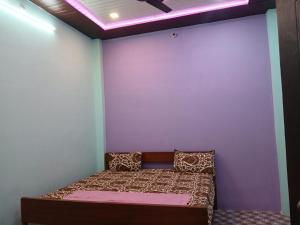 a bed in a room with a white wall at Naimisharanya Atithi Bhavan in Naimishāranya