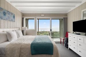 una camera da letto con un letto grande e una televisione di Atlantis Lodge a Pine Knoll Shores