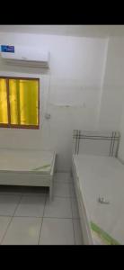 沙迦masqat building的白色的客房设有窗户和瓷砖地板。