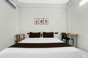 Hotel O Moonlight Residency في Vettutura: غرفة نوم بها سرير أبيض كبير ومكتب +56 صورة