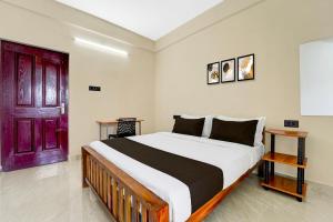 Hotel O Moonlight Residency في Vettutura: غرفة نوم بسرير كبير مع باب احمر