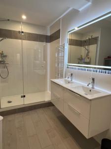 FumelにあるVilla Margotの洗面台2つとシャワー付きのバスルーム