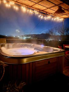 a jacuzzi tub on a deck with lights at Le Mas du Rochet - Gîte à la campagne avec spa privé - 2 à 4 pers in Mirmande