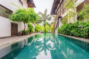 a swimming pool in the middle of a building with trees at Mayci Eco Boutique Hotel Hoi An in Hoi An +72 photos