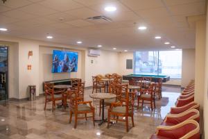 a restaurant with tables and chairs and a pool table at Travohostal Monterrey Historico in Monterrey