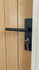 a doorhandle with a key on a wooden door at Ready Stay Work Lodge in Birmingham
