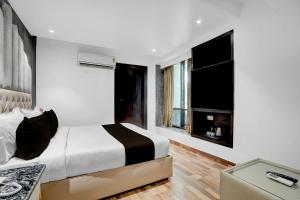 una camera bianca con letto e camino di Hotel O elvilla a Nuova Delhi Altre 21 foto