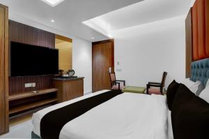 una camera da letto con un letto grande e una TV a schermo piatto di Hotel O elvilla a Nuova Delhi