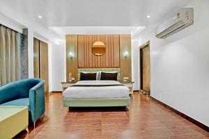 una camera da letto con un letto e un divano blu di Hotel O elvilla a Nuova Delhi