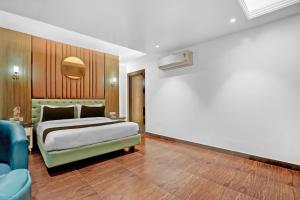 una camera da letto con un letto e un divano blu di Hotel O elvilla a Nuova Delhi