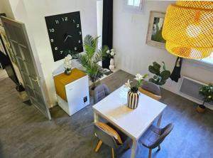 ein Wohnzimmer mit einem Tisch, Stühlen und einer Uhr in der Unterkunft Beautiful apartment in Mont des Oiseaux in Hyères + 4 Fotos