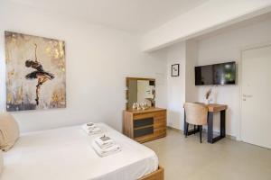 a bedroom with a bed and a desk and a television at Urban Bay Studios in Limassol