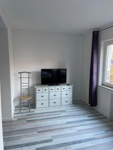 埃克斯特塔尔Möbliertes Wohnen auf Zeit im Extertal的客厅里，梳妆台上放着一台电视机。 更多20张照片