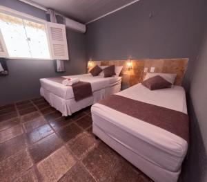 a bedroom with two beds and a window at Pousada Hippopotamus Jeri in Jericoacoara