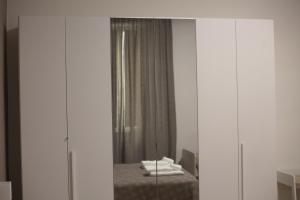 una camera da letto con specchio e un letto con asciugamani di Terrazza Real Poggio a Napoli Altre 23 foto