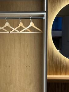 un armadio con uno specchio rotondo e delle grucce di BORGO COMPAGNIA Porta Fredda a Castiglion Fibocchi