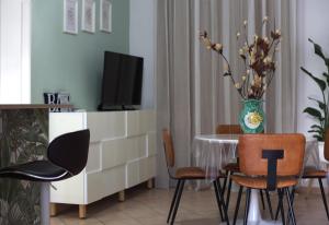 un soggiorno con tavolo, sedie e TV di Terrazza Real Poggio a Napoli