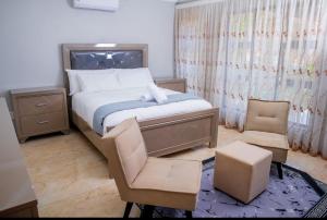 ein kleines Schlafzimmer mit einem Bett und einem Stuhl in der Unterkunft Tindlovu GuestT House in Nelspruit + 4 Fotos