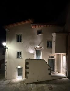 un edificio bianco di notte con una rampa di fronte di BORGO COMPAGNIA Porta Fredda a Castiglion Fibocchi Altre 8 foto