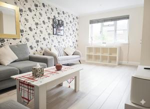 a living room with a couch and a table at Spacious Modern 5 bedroom home near Heathrow Windsor in Canvey