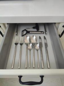 un cassetto pieno di utensili argentati in un cassetto di Апартаменты рядом с Пирамидой a Astana Altre 11 foto