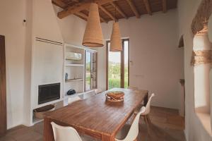a dining room with a wooden table and white chairs at Ibiza Holliday Villa Harmony in Sant Jordi