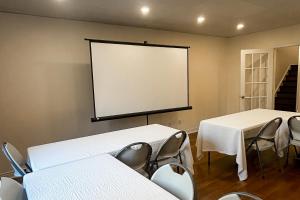 a projection screen in a room with tables and chairs at Monterra in Collingwood