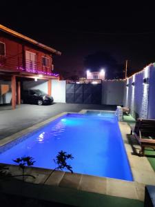 a large blue swimming pool in a yard at night at Raíces Cataratas in Puerto Iguazú