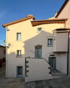 un grande edificio bianco con delle scale di fronte di BORGO COMPAGNIA Porta Fredda a Castiglion Fibocchi