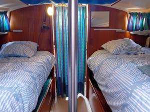 two beds in a room with wood paneling at Voilier au Port de Perros-Guirec in Perros-Guirec