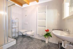 a white bathroom with a toilet and a sink at Apartment Walder in Fiumes