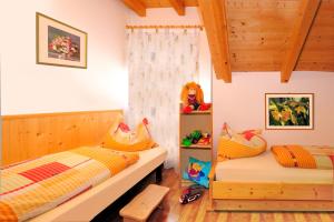 two beds in a room with wooden walls at Apartment Walder in Fiumes