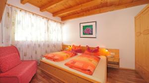 a bedroom with a bed and a red chair at Apartment Walder in Fiumes