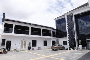 a car parked in a parking lot in front of a building at Olabanji Royal Garden Hotel in Ibadan