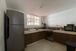 a kitchen with a stainless steel refrigerator and a microwave at Villa del Mar, un espacio funcional y bien ubicado in Progreso