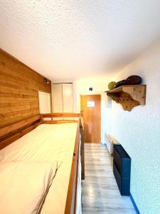 een slaapkamer met een bed en een houten wand bij Métamorphose Au Sommet in Prénatier