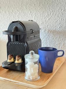 een koffiezetapparaat en een kopje op een tafel bij Métamorphose Au Sommet in Prénatier +4 foto's