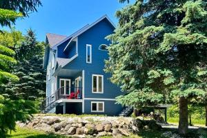 a blue house on a hill with trees at Monterra in Collingwood