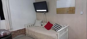 a room with a bed with a tv on the wall at Cabaña HEROES in Villa Los Aromos