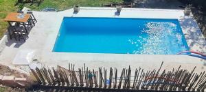 a large blue swimming pool with a fence around it at Cabaña HEROES in Villa Los Aromos