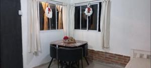 a small table in a room with three windows at Cabaña HEROES in Villa Los Aromos +4 photos