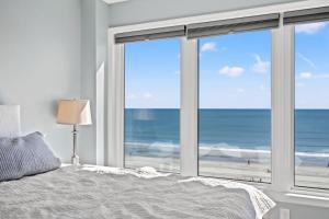 ein Schlafzimmer mit Bett und Blick auf den Strand in der Unterkunft Atlantic Dunes Resort Unit 502 with Direct Oceanfront Balcony in Myrtle Beach + 35 Fotos