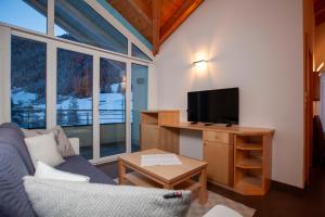 a living room with a couch and a flat screen tv at Alpina Appartements in Nauders