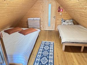 Dos camas en una habitación con paredes de madera. en Cabana Izvorul Rece Maramureş, en Baia-Sprie