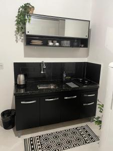kuchnia z czarnym blatem i zlewem w obiekcie Casa aconchegante e privativa w Foz do Iguaçu