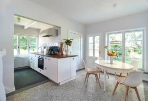 una cucina bianca con tavolo, tavolo e sedie di Gästehaus mit Seminarraum a Meezen
