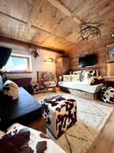 a bedroom with two beds and a room with a cow print at Ciasa de Len Cortina in Cortina dʼAmpezzo