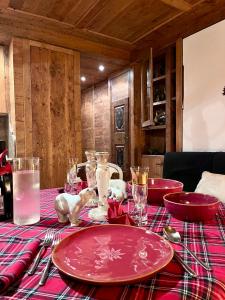 a table with red plates and bowls on top of it at Ciasa de Len Cortina in Cortina dʼAmpezzo +13 photos