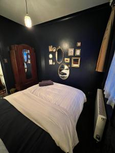 - une chambre avec un lit blanc et un mur noir dans l'établissement Park Crescent Brighton, à Brighton et Hove