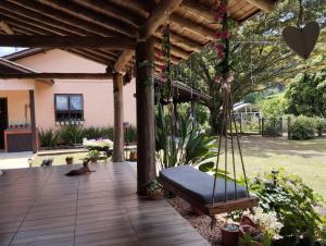 een veranda met schommel in een tuin bij Sítio Herman Natureza Viva in Rolante
